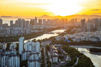 High angle view of modern buildings against sky during sunset