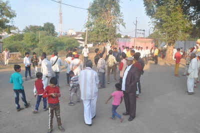 Rear view of people walking on road in city