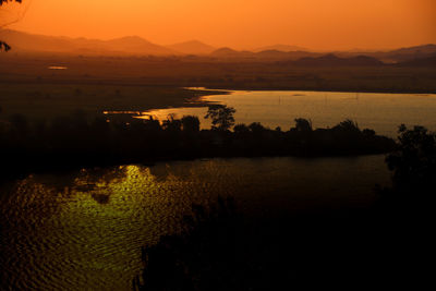 Scenic view of lake against orange sky