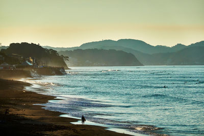 Scenic view of sea with silhouette people against clear sky in the morning