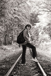 Full length of teenage girl walking on railroad track