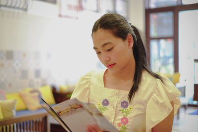 Portrait of young woman looking at book