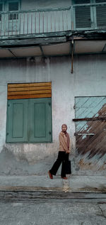 Full length of woman walking against building