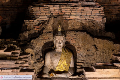 Statue against brick wall of historic building