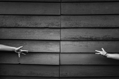 Close-up of hand against wood