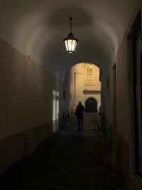 Full length of man walking in illuminated corridor