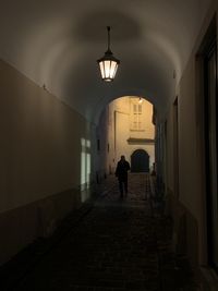 Rear view of people walking in illuminated building