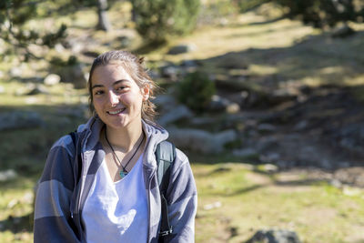 Portrait of smiling woman against trees