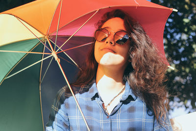 Portrait of young woman wearing sunglasses standing outdoors