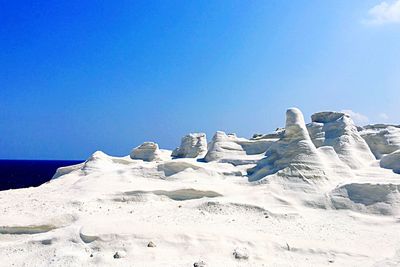 Scenic view of snowcapped mountains against clear blue sky