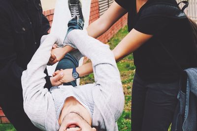 Midsection of friends enjoying at yard