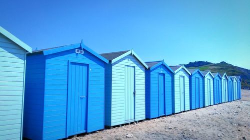 Beach huts against clear blue sky