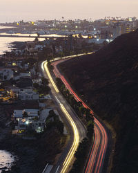 High angle view of light trails on road amidst buildings in city