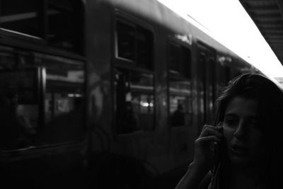 Young women with a cellphone behind a trainstation