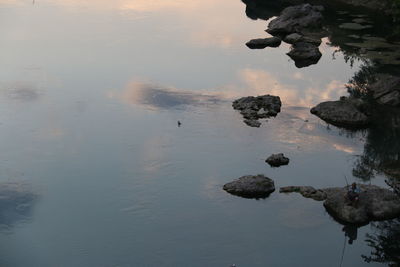 High angle view of rocks in lake against sky