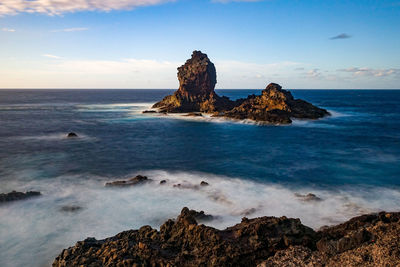 Scenic view of rocks on beach against sky