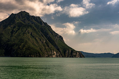 Scenic view of sea and mountains against sky