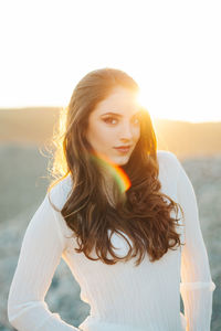 Portrait of beautiful woman standing against sky during sunset