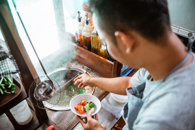 Side view of man preparing food in kitchen