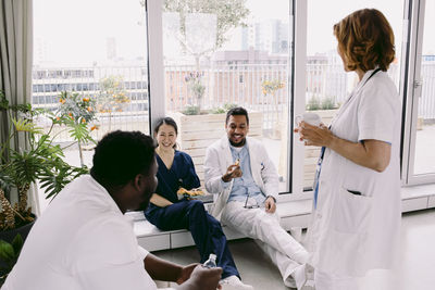 Happy medical colleagues discussing during break at hospital