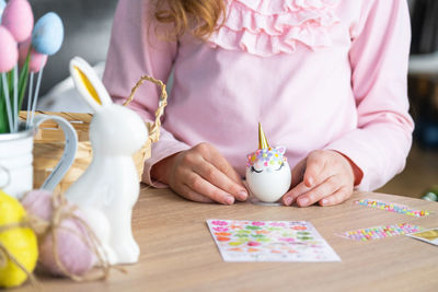 Midsection of woman with gingerbread cookies on table