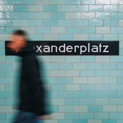 Blurred motion of person walking against wall