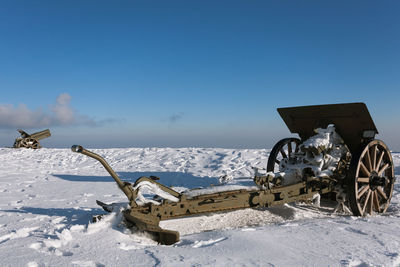 Bicycles parked on snow covered land against sky