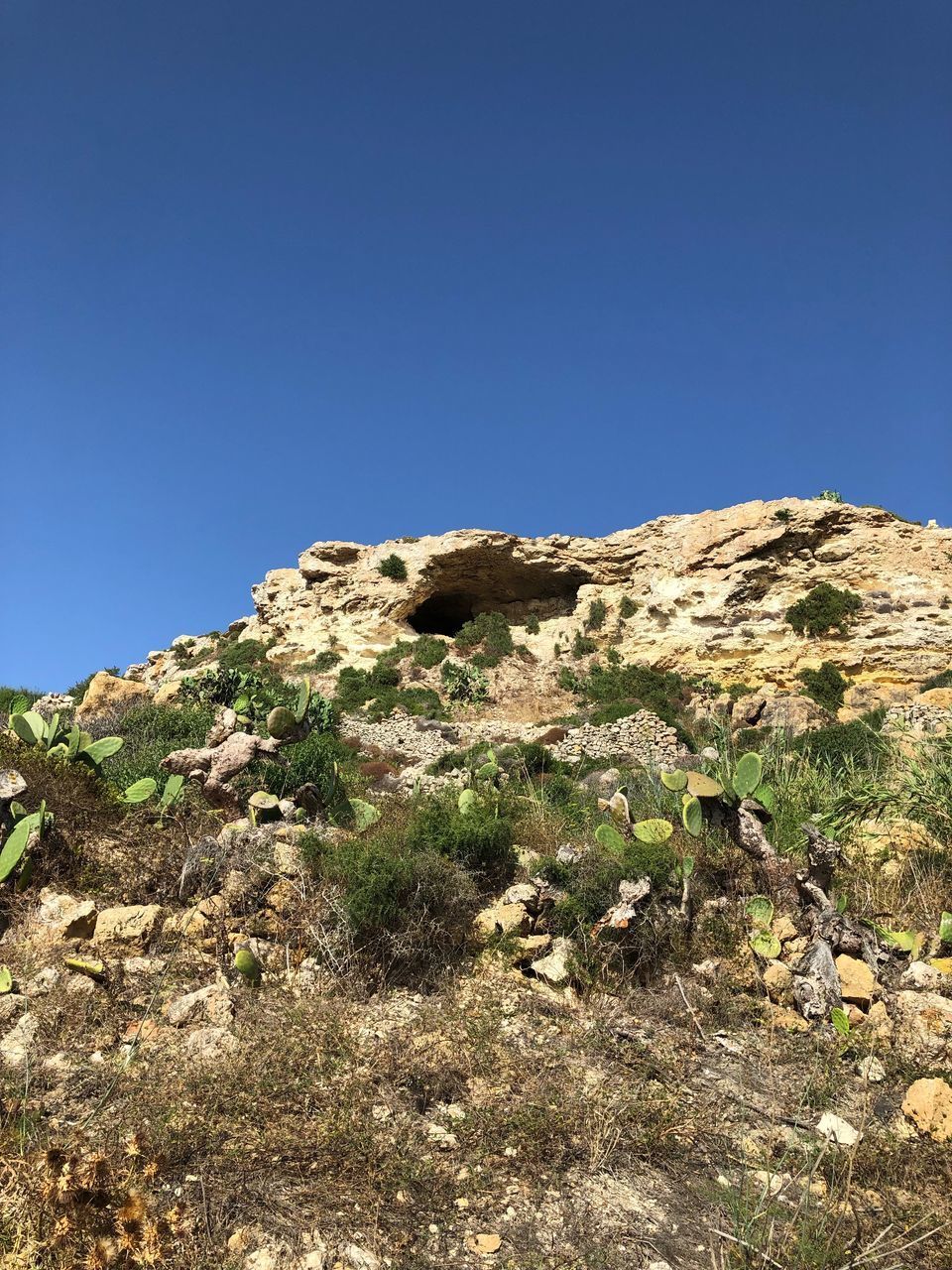 LOW ANGLE VIEW OF ROCK AGAINST CLEAR BLUE SKY
