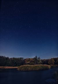 Scenic view of lake against sky at night