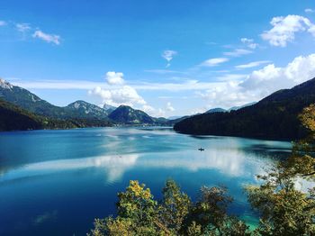 Scenic view of lake and mountains against blue sky