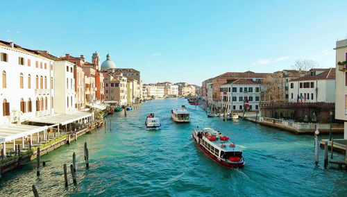 Boats in canal amidst buildings in city