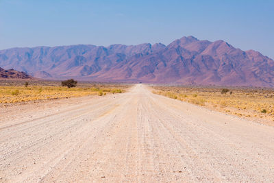 Road amidst desert against sky