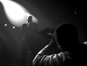 Man photographing a singer