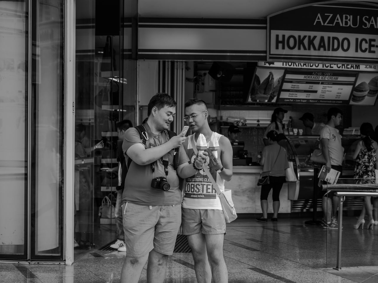 lifestyles, casual clothing, leisure activity, text, communication, standing, men, person, western script, young adult, indoors, front view, young men, full length, togetherness, city life