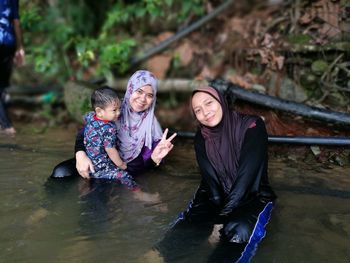 Rear view of women sitting in water