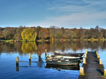 Wooden posts in lake against sky