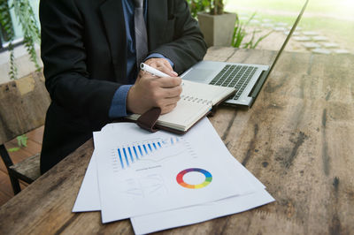 Man using mobile phone while sitting on table
