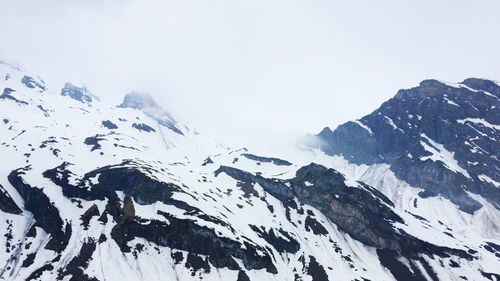 Low angle view of mountain against sky during winter