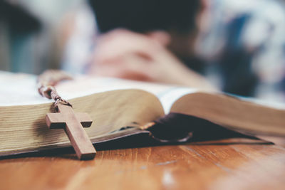 Close-up of rosary on open bible at table