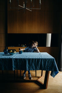 Woman sitting on chair by table