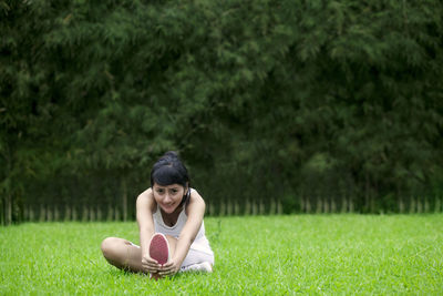 Portrait of woman doing yoga on field