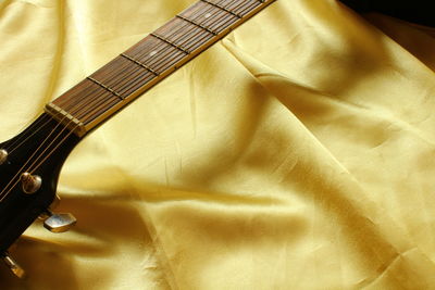 Cropped image of guitar on fabric