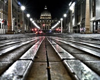 Illuminated railroad tracks in city at night