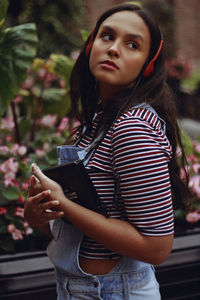 Close-up of girl listening music outdoors