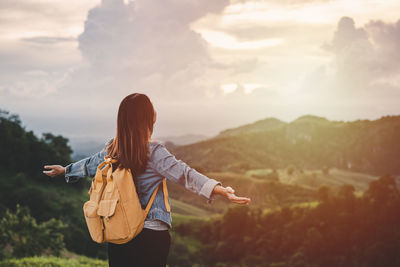 Rear view of woman standing against sky