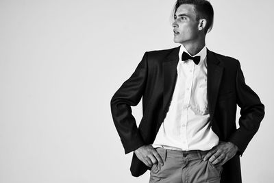 Portrait of young man standing against white background