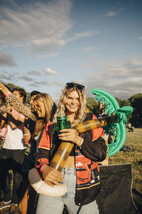 Portrait of woman holding balloon while having fun with friends at concert