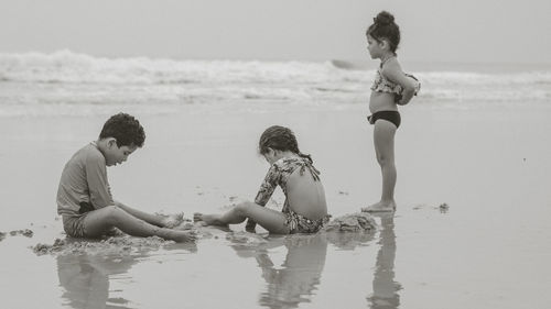 Rear view of children on beach