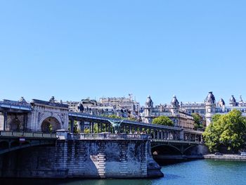 Bridge over river against clear blue sky