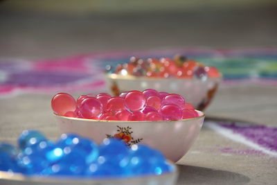 Close-up of colorful marbles in bowls on floor